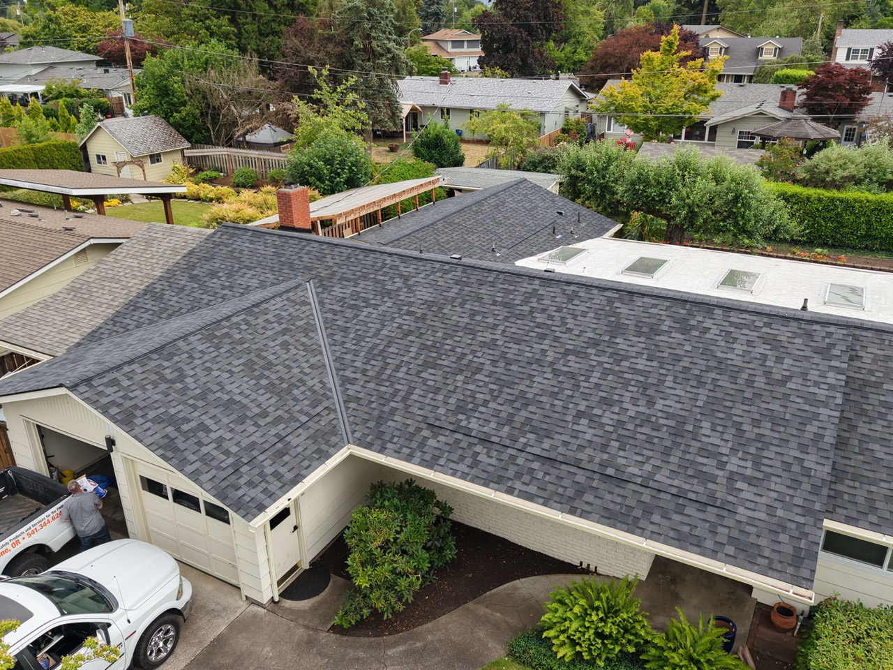 Aerial view of a completed dark-gray architectural asphalt shingle roof.